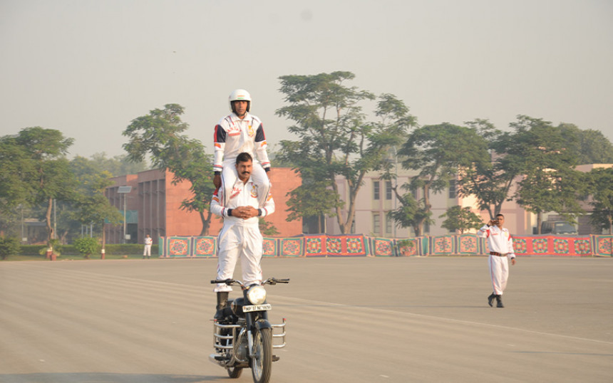 Riding a Bike while Standing on Seat Bracket and carrying one Adult man on Shoulder